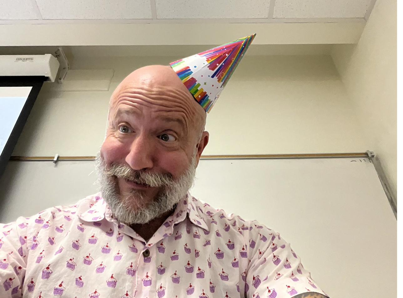 Barclay Barrios makes a humorous face wearing a party hat.