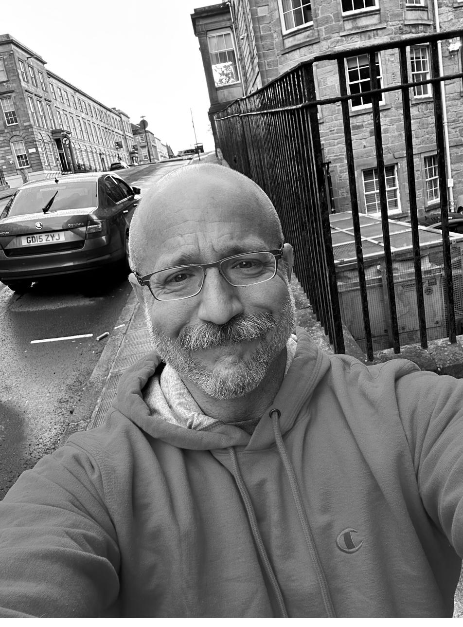 Barclay Barrios walking along a sidewalk in the rain.